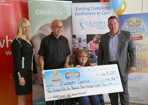 50/50 Plus lottery winner Elizabeth Garcia (seated) and her husband Antonio (second from left) receive their big cheque from LHSF Chief Operating Officer Evelyn Salhani (left) and CHF President & CEO Scott Fortnum (right). 50/50 Plus lottery winner Elizabeth Garcia (seated) and her husband Antonio (second from left) receive their big cheque from LHSF Chief Operating Officer Evelyn Salhani (left) and CHF President & CEO Scott Fortnum (right).